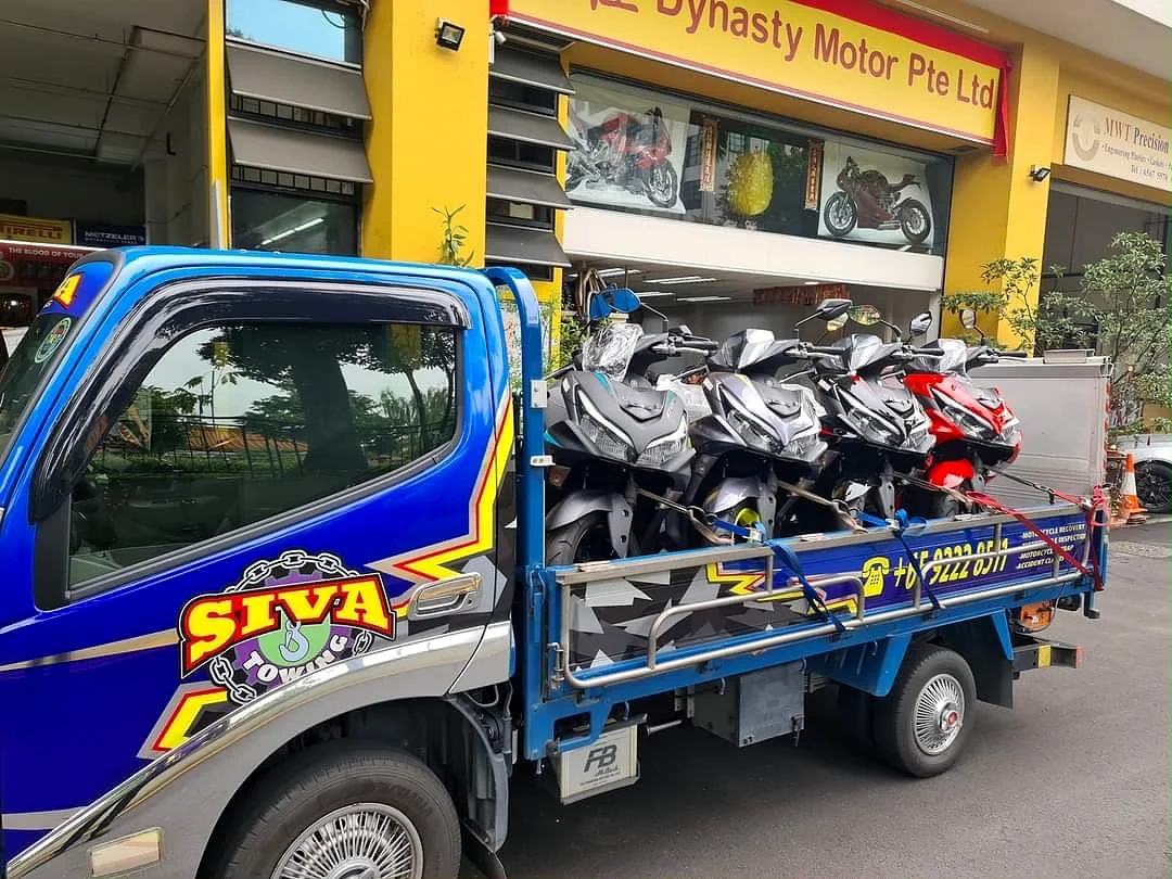 Siva Towing lorry collecting motorcycles outside a workshop in Singapore