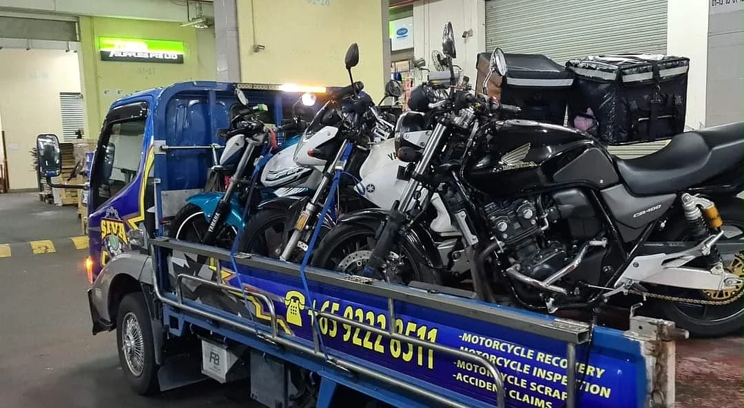 Multiple motorcycles secured on a Siva Towing recovery lorry in Singapore