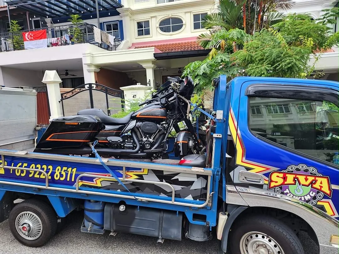 Motorcycle secured on a branded Siva Towing lorry during a workshop transfer